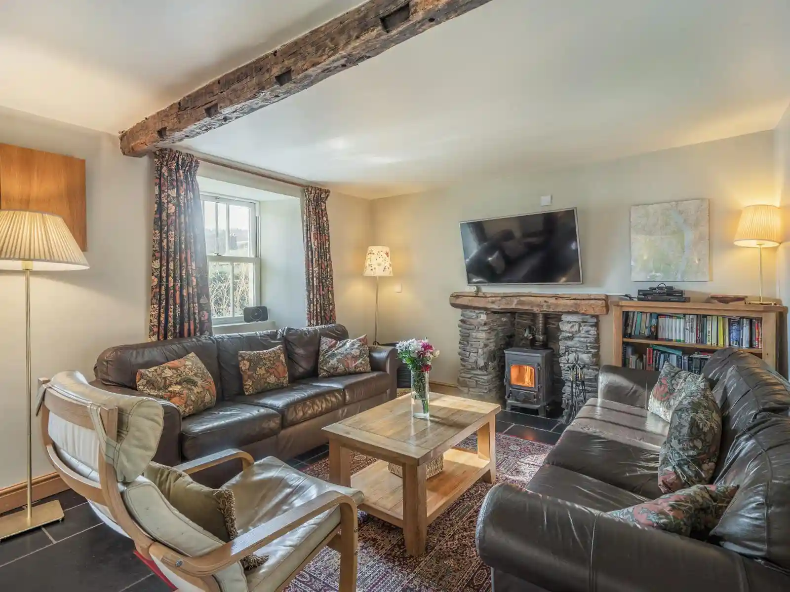 The lounge with sofas, tv and a roaring fireplace