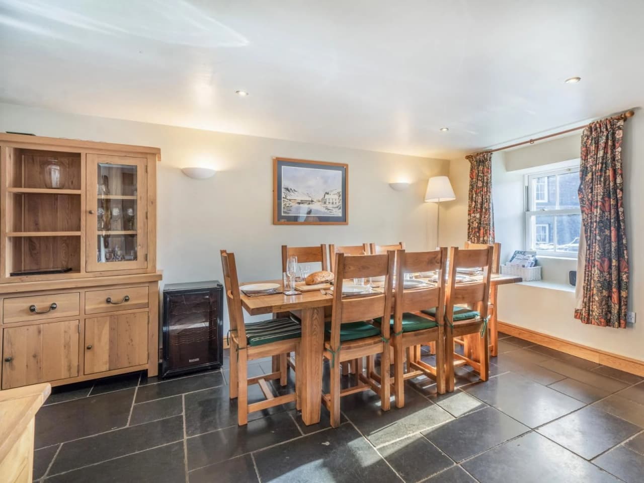 The dining area with a large oak table and eight chairs