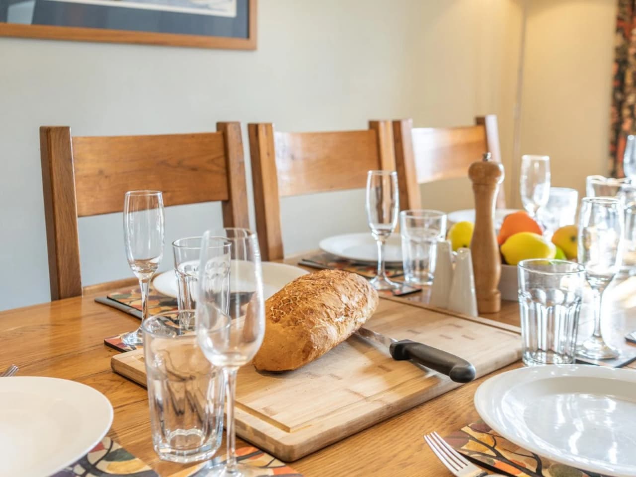 A close up of the dining table laid with fresh bread and fruit