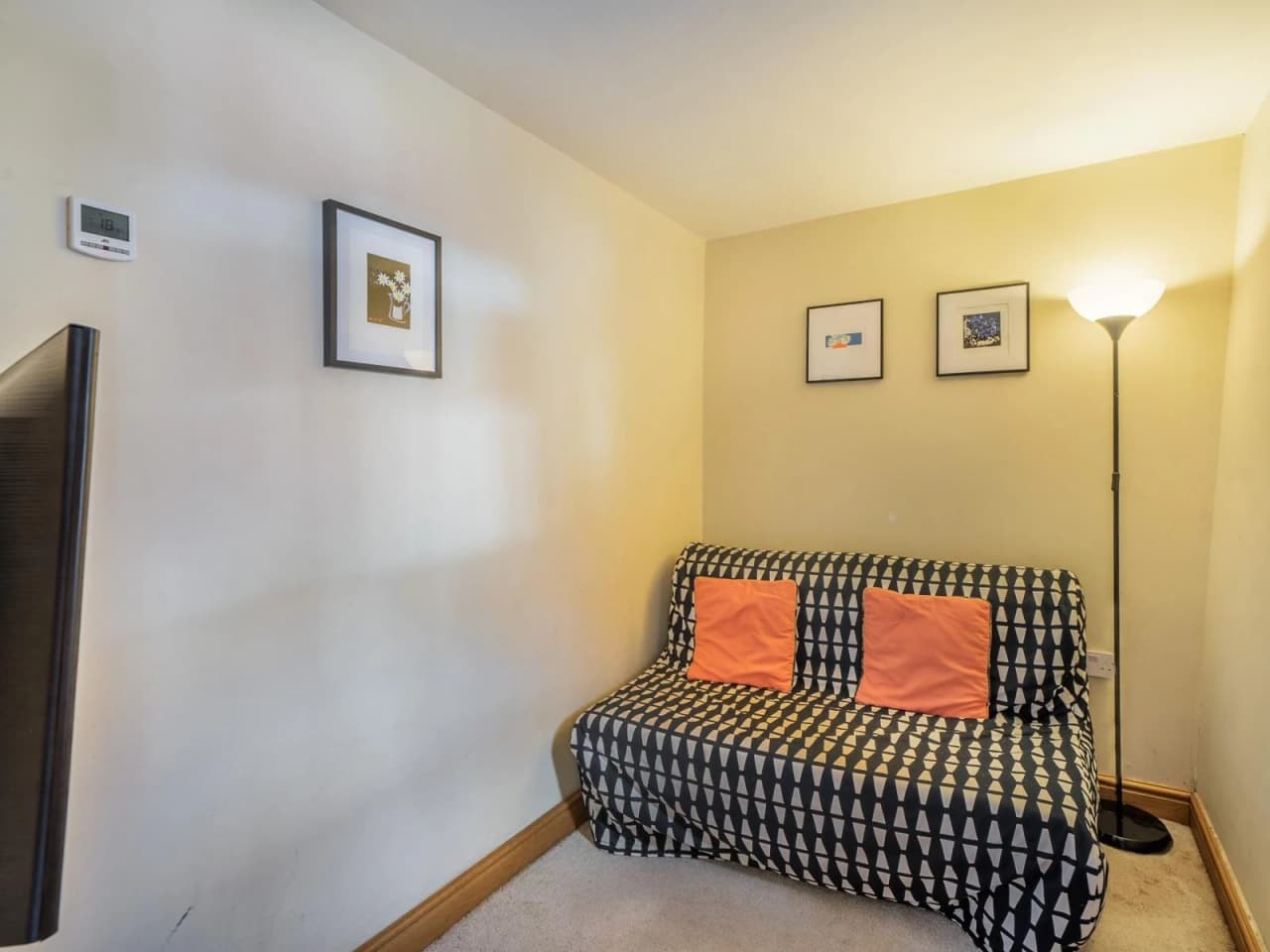 Looking into the snug room downstairs with a sofa bed and tv on the wall