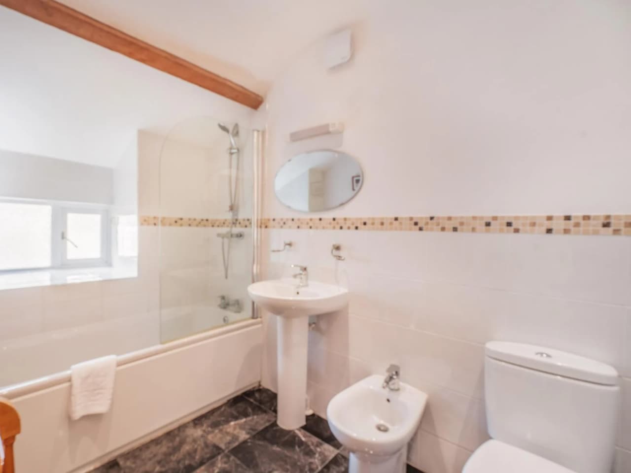 The upstairs bathroom with a bath tub and shower, bidet and toilet
